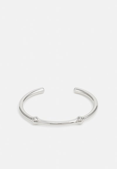 Bracciale in argento con una finitura liscia e lucida. Presenta due estremità arrotondate e un design semplice e minimalista.