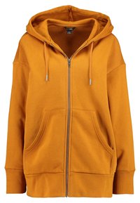 Sudadera naranja con capucha, cierre de cremallera en la parte delantera, grandes bolsillos frontales y cordones. Tejido suave y corte relajado. Adecuada para uso informal.