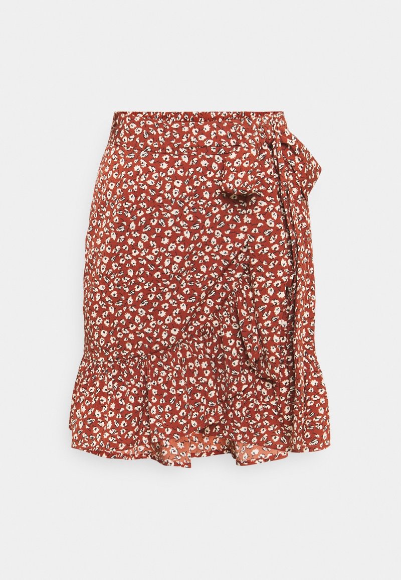 Jupe portefeuille à motif floral couleur rouille avec petites fleurs blanches, ourlet volanté et détail de taille nouée sur un fond uni.