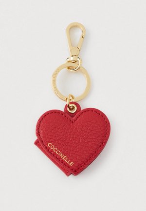 Portachiavi a forma di cuore in pelle rossa testurizzata con moschettone e anello dorati, con "COCCINELLE" impresso in oro sul cuore.