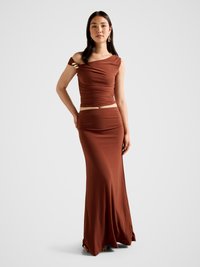 Rjavo, tesno prilegajoče se dvodelno oblačilo z zbranim zgornjim delom z odkritimi rameni in tekočo, do gležnjev segajočo krilo. Detajli v zlatih tonih.