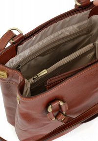 Bruine leren handtas met schouderriem, voorzien van meerdere compartimenten, een ritsvak en een decoratieve metalen gesp als detail.