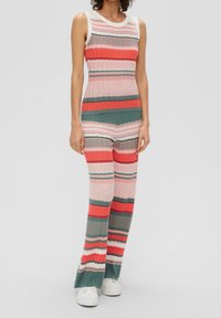 Ensemble tricoté rayé dans des teintes de corail, rose et vert. Comprend un haut sans manches avec de larges épaules et un pantalon à jambes évasées avec un motif texturé.