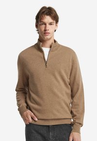 Brauner Reißverschluss-Pullover aus weichem Stoff, mit einem hohen Kragen und gerippten Bündchen. Das Design ist schlicht ohne sichtbare Muster oder Akzente.