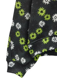 Czarny sweter w kwiatowy wzór. Posiada zielone i białe kwiaty, ściągacze przy mankietach oraz teksturowany materiał. Dodatki obejmują nierówne krawędzie.