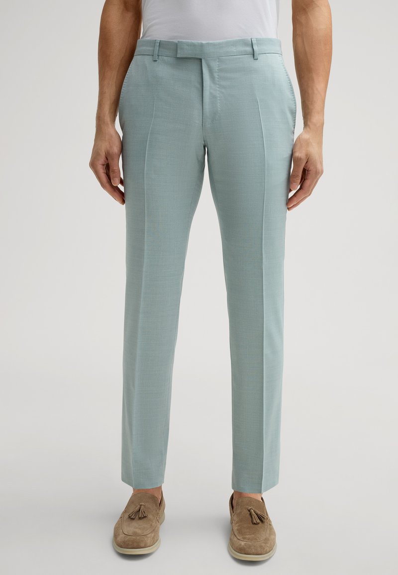 Himmelblaue maßgeschneiderte Hose aus strukturiertem Material, mit flachem Vorderteil, Seitentaschen und Slim Fit. Kombiniert mit braunen Slippern.