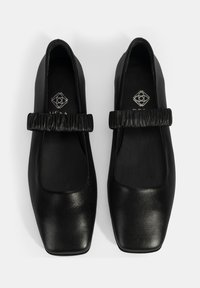 Schwarze Lederflachschuhe mit eckiger Zehenpartie und einem gerafften schwarzen Riemen über dem Rist. Glatte Textur, elegantes Design und minimalistische Details.