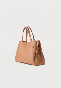 Sac fourre-tout en cuir beige avec doubles poignées, forme rectangulaire, texture lisse et design minimaliste ; comporte de petits accents latéraux.