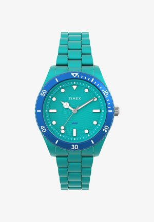 Türkiz Timex óra hullámmintás számlappal, kék kerettel és rozsdamentes acél szíjjal. Fehér órajelzők és mutatók a jobb láthatóság érdekében.