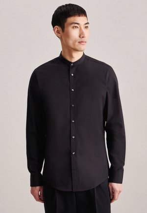 Chemise noire à manches longues avec col band, présentant un devant boutonné et un léger éclat, fabriquée en tissu lisse.