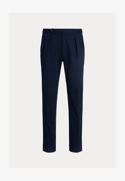 Παντελόνια σε στενή γραμμή χρώματος ναυτικού μπλε με κουμπιά στο πλάι, πλισέ μπροστά, σχεδιασμένα σε απλό ανοιχτό φόντο.
