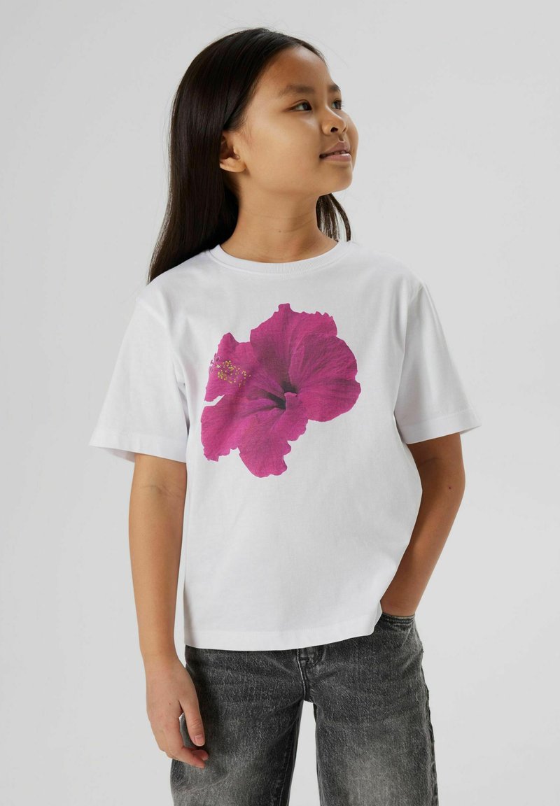 Hvid t-shirt med et stort magenta hibiscus blomsterprint på forsiden, med korte ærmer og en afslappet pasform.