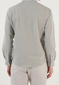 Camicia a maniche lunghe a righe in grigio chiaro e bianco, con colletto classico e polsini abbottonati, realizzata in un morbido tessuto con una finitura testurizzata.