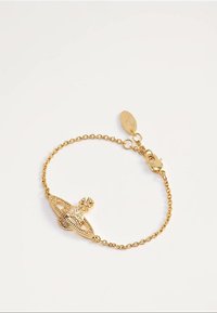 Bracelet délicat en chaîne d'or avec un pendentif en forme d'orbe orné d'un détail en croix et une étiquette ovale près du fermoir sur fond blanc.