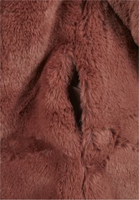 Manteau en fausse fourrure d'une teinte chaude brun rougeâtre. Texture douce et moelleuse avec une poche cachée et une doublure intérieure lisse.