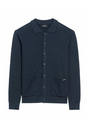 Granatowy prążkowany kardigan z zapięciem na guziki, spiczastym kołnierzykiem, dwiema przednimi kieszeniami i małą metką marki na lewej kieszeni.