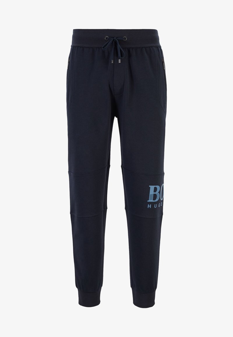 Marineblaue Jogginghosen aus weichem Stoff, mit einem Tunnelzug an der Taille, seitlichen Reißverschlusstaschen und einem blauen Logodruck am linken Oberschenkel.