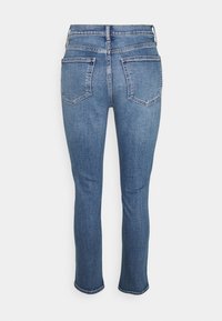 Modré džíny z denimu s mid-rise pasem, slim fit a zkrácenou délkou. Obsahují dvě zadní kapsy a decentní detaily šití.