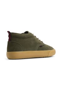 Zapatillas altas de ante verde oliva con suela de goma marrón, que presentan cordones marrones y una tira de agarre a rayas contrastante en la parte trasera.