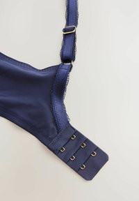 Brazilă albastră închis cu dantelă, bretele ajustabile și accesorii de culoare aurie. Prezintă închidere cu cârlige și ochiuri, cu multiple opțiuni de ajustare.