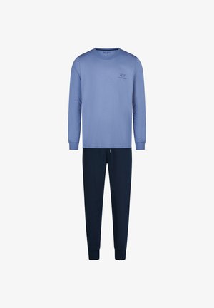 Hellblaues Langarmshirt mit kleinem Text auf der Brust, kombiniert mit dunkelblauen, gerade geschnittenen Hosen, vor weißem Hintergrund.