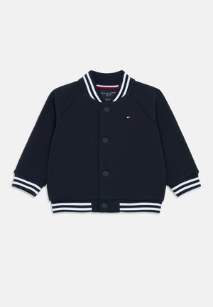 Marineblaue Collegejacke im Stil mit einem weiß gestreiften Rippkragen und -bündchen, Knopfverschluss und dezentem Logo-Detail auf der linken Brust.