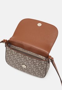 Prostokątna torebka na ramię z brązową skórzaną klapką i beżowym, wzorzystym korpusem. Wyposażona w zatrzask i pojedynczy pasek na ramię.