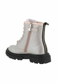 Stivaletto metallico argento con tomaia texture, suola nera spessa, chiusura con zip laterale e linguetta a strisce in contrasto sul retro.