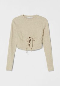 Beige, geripptes, langärmeliges Cropped-Top mit rundem Ausschnitt und Schnürdetails an der Vorderseite. Weicher Stoff mit taillierter Silhouette.