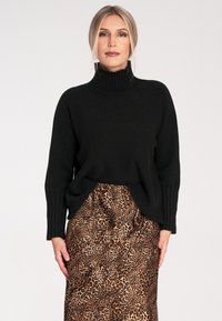 Czarny dzianinowy sweter z golfem i prążkowanymi mankietami, w poł�ączeniu z satynową spódnicą w leopardzi wzór z elastyczną talią.