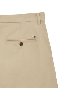 Pantaloni beige con fronte piatto, una tasca posteriore a filetto con bottone e un piccolo logo in metallo. Tessuto con una superficie liscia.
