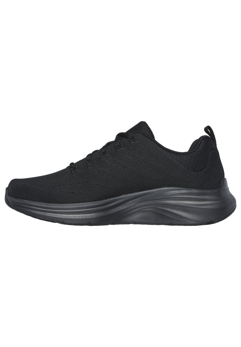 Scarpe sportive nere con tomaia in tessuto testurizzato, suola intermedia nera liscia e dettagli curvi delicati. Presentano un design con lacci e una linguetta per il sollevamento.