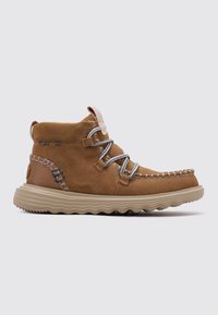 Scarpa alta in suede marrone con lacci grigi, dettagli di cucitura e una suola in gomma beige testurizzata con un motivo a onde.