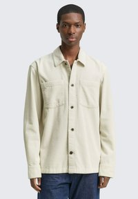 Katoenen corduroy shirt in lichtcreme met een knoopsluiting aan de voorkant, twee borstzakken en lange mouwen, met een gestructureerd ribontwerp.