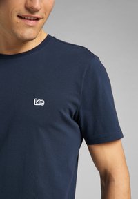 T-shirt blu navy a maniche corte in cotone, con un piccolo logo ricamato bianco "Lee" sul lato sinistro del petto e collo rotondo.