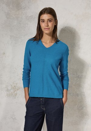 Pull à col en V, à manches longues, de couleur bleu vif, fabriqué en tricot doux. Il présente un détail de couture central et des poignets côtelés.