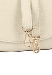 Crème textuur leren tas met goudkleurige hardware en sluitingen, met een glad ontwerp en dubbele ritsluiting.