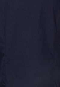 Mornarska tkanina s glatkom teksturom, koja prikazuje uniformnu boju i minimalne šavove. Površina je mat bez vidljivih uzoraka ili hardvera.