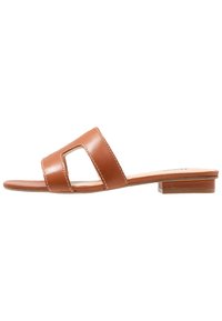 Brown leather slide sandal with two wide straps, a square cutout, and a low block heel. Features white stitching along the edges.