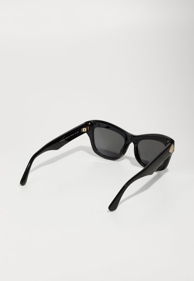 Ochelari de soare negri cu rame supradimensionate și unghiulare, lentile întunecate și un finisaj din plastic neted. Prezintă accente subtile din hardware auriu pe laterale.
