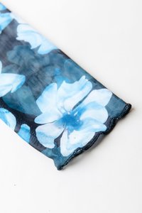 Tkanina z vzorcem rož z modrimi cvetovi na temnem ozadju. Mehka tekstura z valovito robom. Lahka in prožna zasnova.