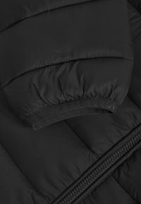 Svart pufferjacka med quiltat mönster, elastisk mudd med "POLO CLUB"-branding och en smidig dragkedja.