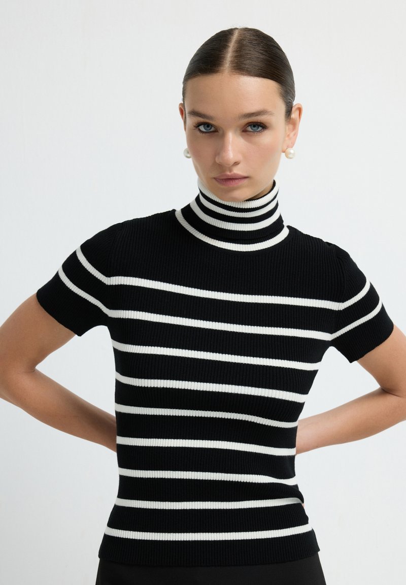 Černobíle pruhovaný krátký rukáv turtleneck top z žebrovaného úpletu, s upnutým střihem a kontrastními bílými horizontálními pruhy.