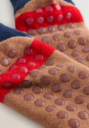 Texturerade handskar med en brun bas som har röda och blå ränder samt klara gummidots för grepp. Mjukt material med stickad yta.
