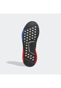 Black athletic shoe sole with a honeycomb pattern, red and blue accents on the sides, and a textured surface for grip and flexibility.