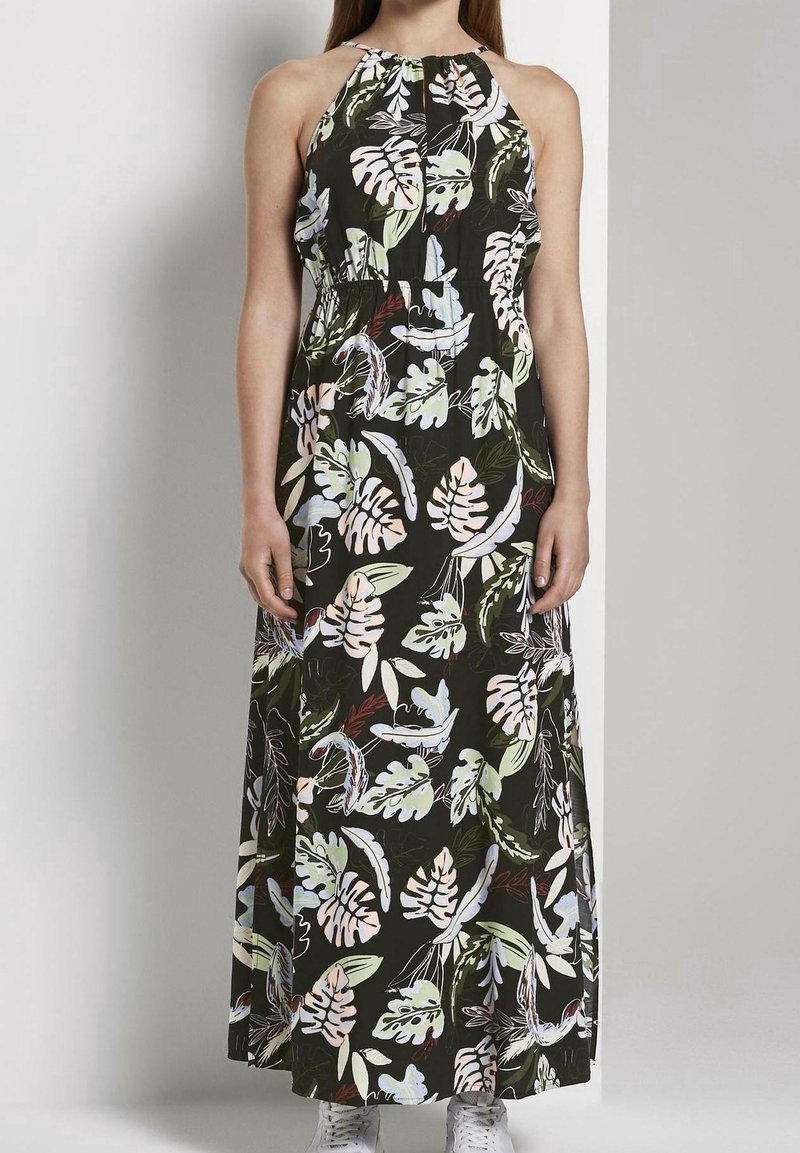 Robe longue en tissu léger avec un fond sombre orné de motifs colorés de feuilles. Conception à col halter avec un détail froncé au niveau de la poitrine.