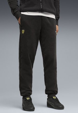 Sorte fleece joggers med sidelommer, prydet med et gult Ferrari-logo. Komfortabel pasform med ribbede manchetter og en blød tekstur.