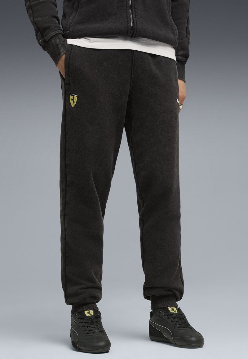 Sorte fleece joggers med sidelommer, prydet med et gult Ferrari-logo. Komfortabel pasform med ribbede manchetter og en blød tekstur.