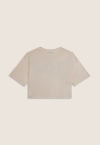 Camiseta corta beige hecha de algodón suave, con mangas cortas y cuello redondo. La parte posterior presenta un diseño sutil de color claro.