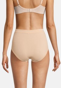 Mutande beige a vita alta con una texture liscia e morbida. Design semplice, bordi senza cuciture e senza hardware o decorazioni visibili.